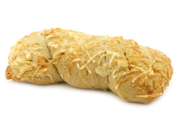 freshly baked spelt bread covered with grated cheese and a cut one on a white background