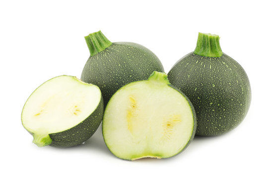 fresh round zucchini's and a cut one on a white background