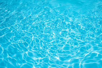 Fototapeta na wymiar Blue water abstract in swimming pool, water surface with sun reflection in swimming pool