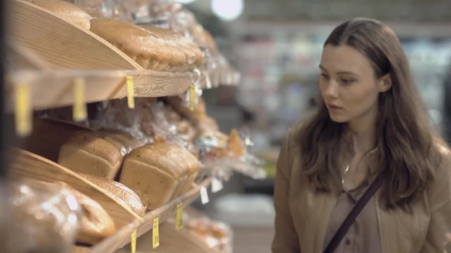 Woman buying fresh bread in a supermarket