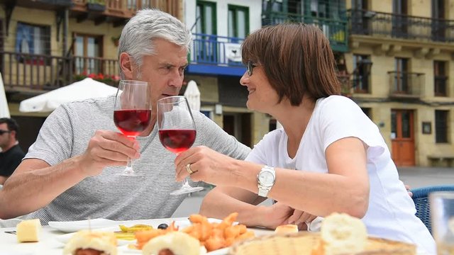 Senior couple eating and drinking wine