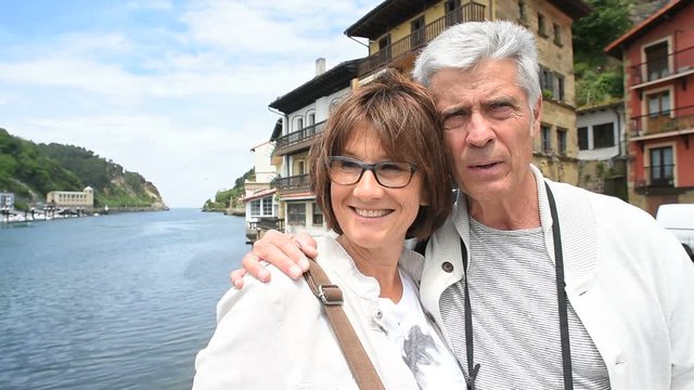 Senior couple of tourists visiting spanish little town