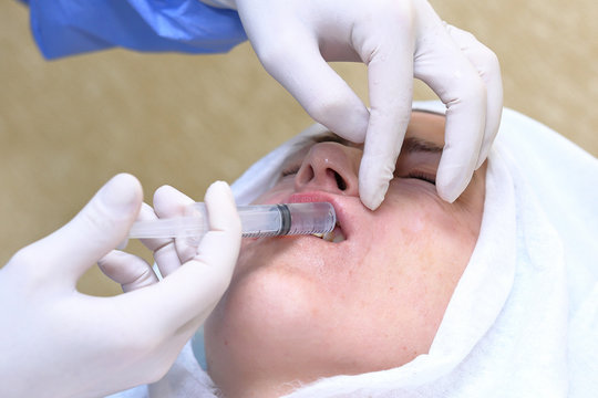 Woman gets anesthetic injection in mouth.