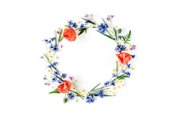 floral frame with red poppies, chamomile flowers, cornflowers and green branches. Flat lay, top view