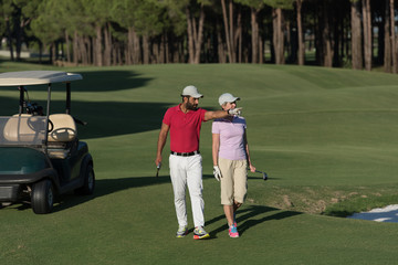 Obraz premium couple walking on golf course