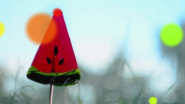 Red Lollipop in the shape of watermelon slices.Rotation and cartoon effect. Loop