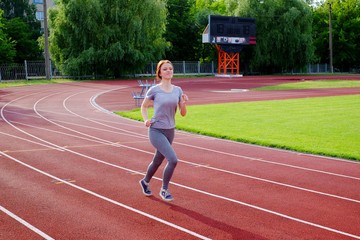 Fototapeta premium Girl runs at the stadium