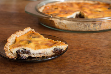 Part of cake with cottage cheese and prunes in plate.