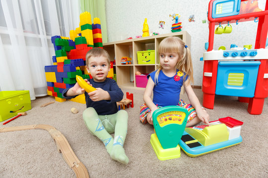 Two kids play role game in toy shop at home
