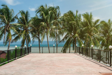 Fototapeta premium concrete platform surrounded by a fence and palm trees