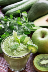 Green vegetable smoothie and ingredients.