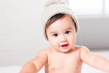 beautiful baby boy with a gray hat smiling