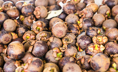 Fresh mangosteen for sale at an outdoor market.