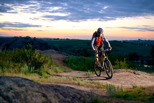 Cyclist Riding the Bike on the Mountain Rocky Trail at Sunset © Maksym Protsenko