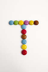 La lettera T formata da coloratissimi confetti di cioccolato.