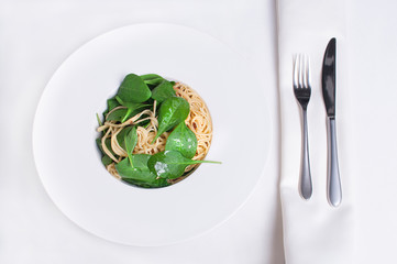 Spaghetti z zielonym szpinakiem, danie wegetariańskie podane w eleganckiej restauracji. - obrazy, fototapety, plakaty