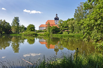 Fototapeta na wymiar Kirche von Sankt Kilian mit Spiegelung im Teich