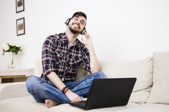 Young man sitting at home and listening music
