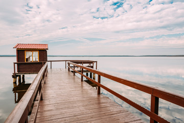 Old Wooden Pier For Fishing, Small House Or Shed And Beautiful L