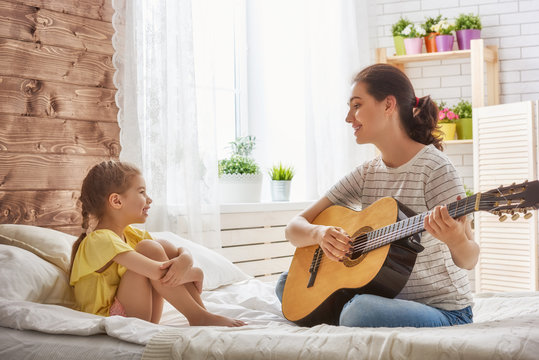 Mother and daughter playing guitar
