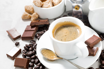 cup of espresso, coffee beans and sweets, closeup