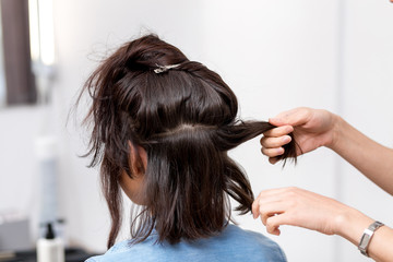 Fototapeta premium stylist hairdresser in barber shop doing haircut closeup of work