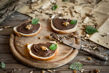 Slices of bread with chocolate cream nuts and knife. Close up. 