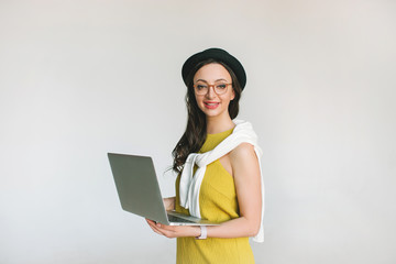 Young pretty businesswoman with laptop smiling over white backgr