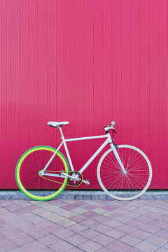 City bicycle fixed gear on red wall.