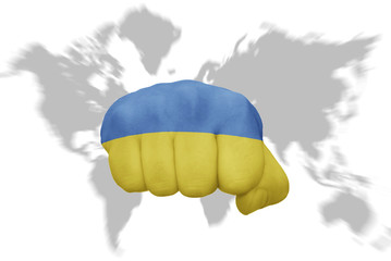 fist with the national flag of ukraine on a world map background