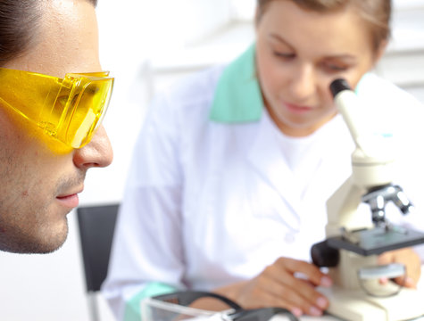 scientist in protective yellow sunglasses and his colleague in l