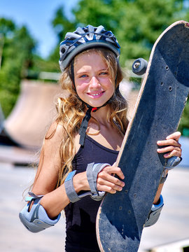 Teen skateboarding his skateboard outdoor. Girl holding skate on his head. Childhood with skateboarding .