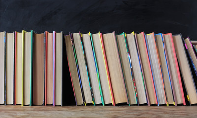 Books on the shelf in the background of a school blackboard.