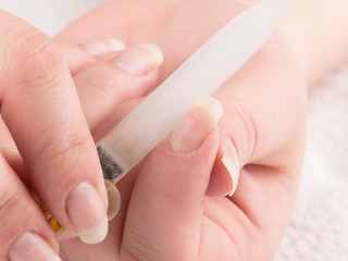 Woman using nailfile during making menicure herself