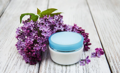 Obraz na płótnie Canvas moisturizing cream and lilac flowers