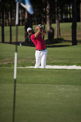 golfer hitting a sand bunker shot