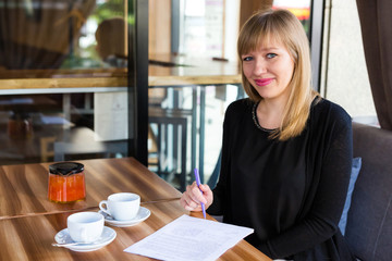 woman drinking tea and working with business papers