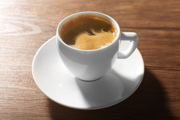 Cup of fresh coffee on wooden background
