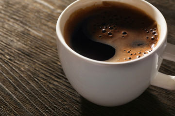 Cup of fresh coffee on wooden background