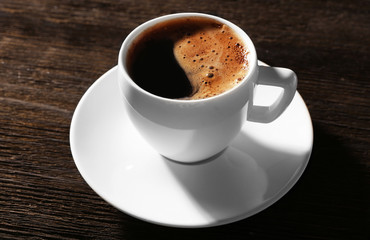 Cup of fresh coffee on wooden background