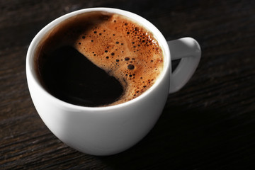 Cup of fresh coffee on wooden background