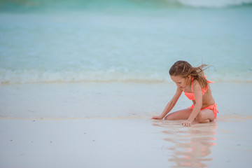 Little kid playing on white beach