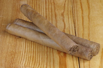 Handmade cigars on a wooden table.