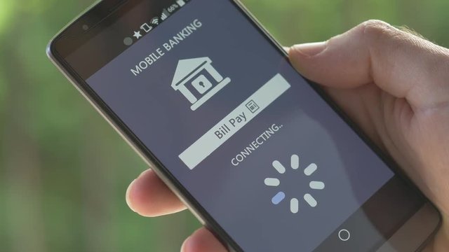 Paying a store or provider bill is now possible directly from a smartphone. The finger is pressing the button to accept to pay with the mobile banking application.