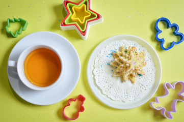 image of cookies on white plate with molds and cup of tea