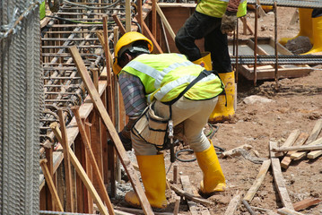 Construction workers fabricating timber form work mostly using plywood at the construction site in...