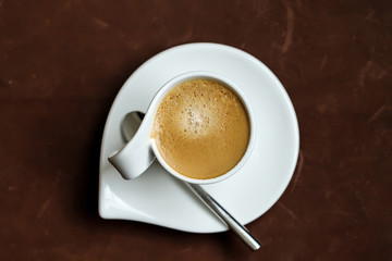 Cup of Espresso on a saucer with a spoon. Top view