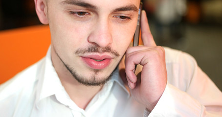 Closeup portrait of handsome business man using cell phone at th