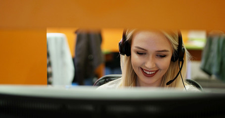 Attractive young woman in suit sitting at call center office and