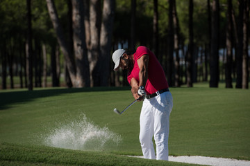 golfer hitting a sand bunker shot